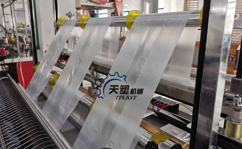 An operator is monitoring a six-lane bag-making machine that simultaneously feeds multiple rolls of film.